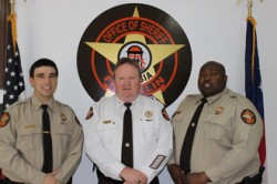 Sheriff stands with new recruits Luke Bennett, left and Antwan McCurry, right.