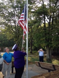 Purple Heart Chapter President Ferris Johnson raises the flag as City Mgr Gary Fesperman looks on