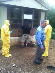 Investigators wear haz-mat suits as they remove over 20 dogs and puppies from a home on Holly Springs Rd Tuesday